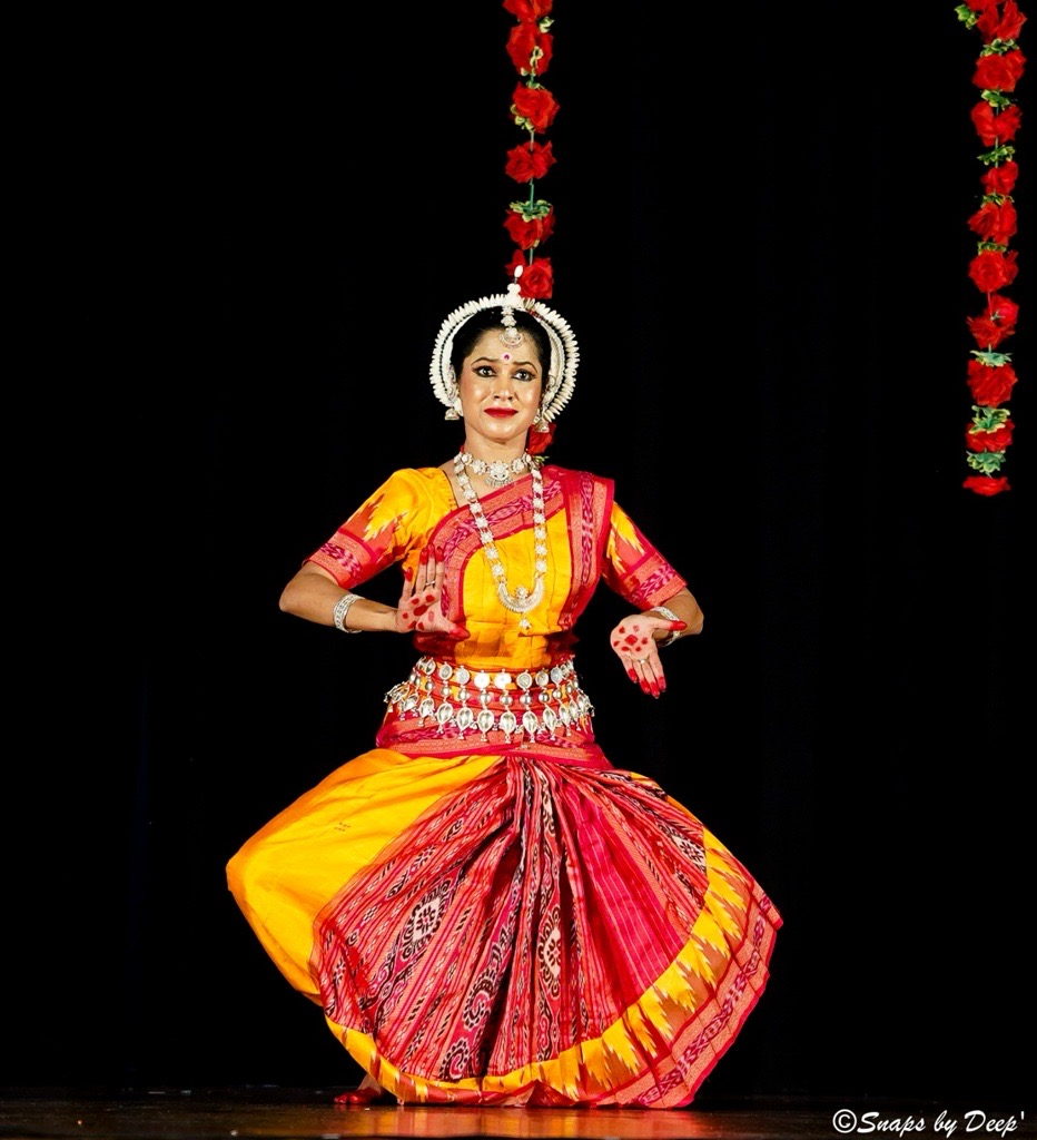 Odissi classical dancer in a traditional yellow and red costume